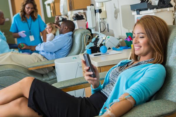 Photo of female blood donor on mobile device.
