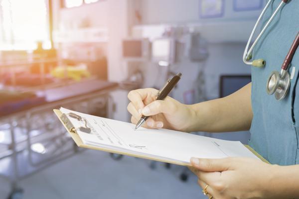 Photo of doctor or nurse signing form.