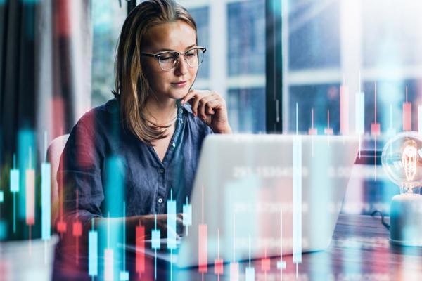 Woman sitting in front of laptop viewing charts.