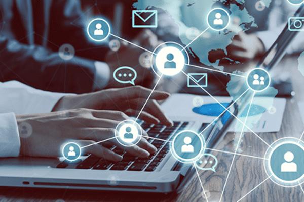 Photo of hands typing on laptop keyboard with digital icons hovering.