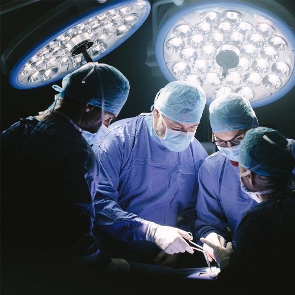 Photo of four doctors performing surgery.
