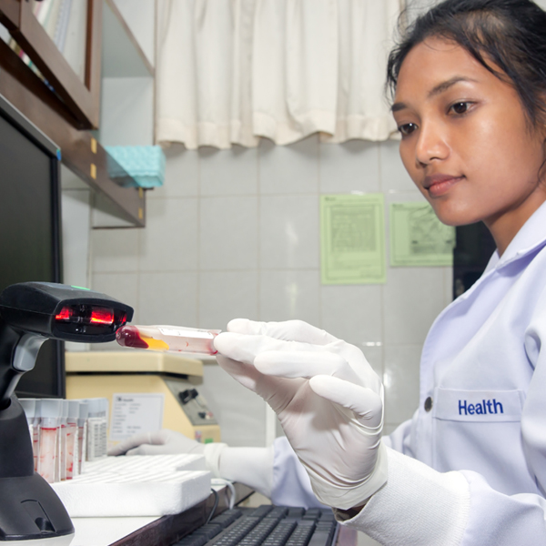 Photo of medical lab person scanning barcode on vile of blood sample.