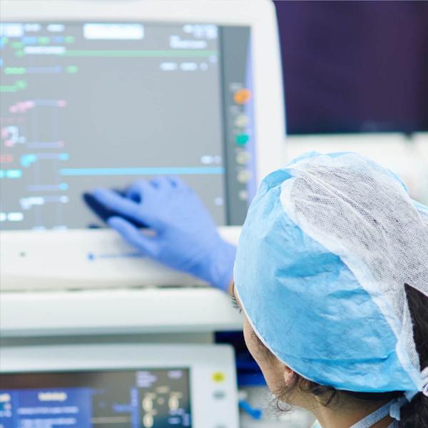 Photo of hospital technician touching medical health system monitor.