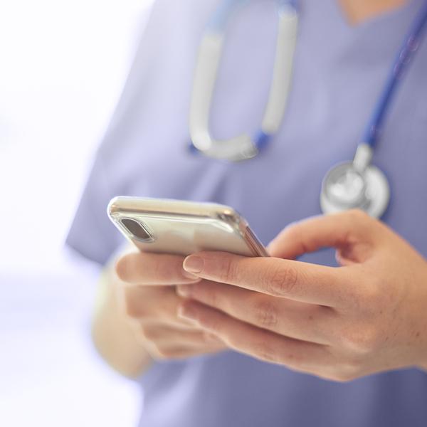 Photo of nurse or doctor using Invita mobile app on smart phone.