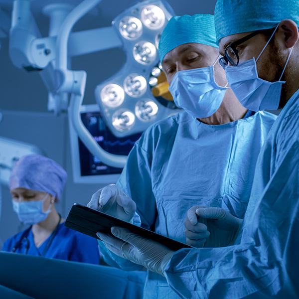 Surgeons working in a hospital looking at InVita on screen.
